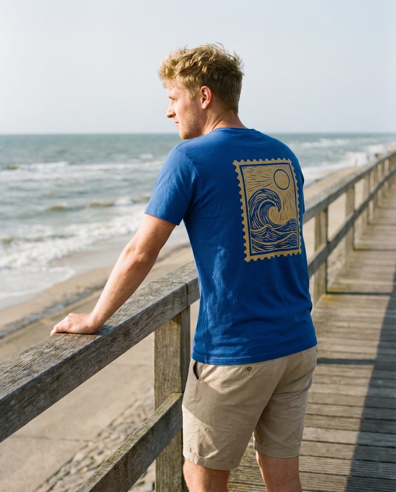 Mann im royalblauen T-Shirt „Die Welle“ an der Promenade